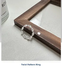 Detail of S925 sterling silver twisted ring with elegant woven texture on wood frame