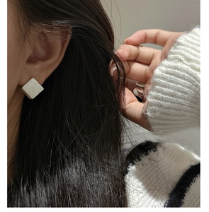 Gros plan de boucles d'oreilles carrées en argent sterling S925 avec finition brossée