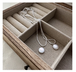 Macro detail of S925 silver necklace with shimmering baroque shell pearls in a jewelry box