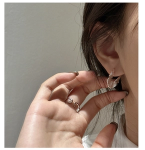 Close-up of S925 silver earrings with fan-shaped texture and a minimalist open ring