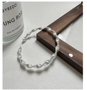 Detailed view of S925 sterling silver twisted open bangle with minimalist wave texture
