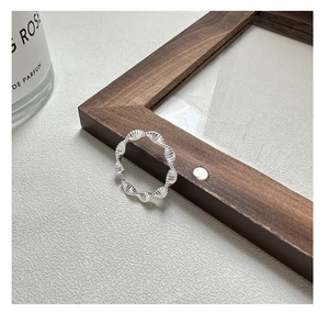Detail view of S925 silver wavy twisted ring showing textured metallic finish and open design