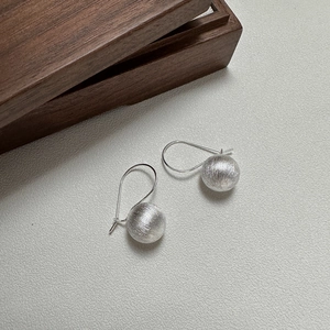 Minimalist S925 sterling silver ball drop earrings with brushed matte finish on grey background