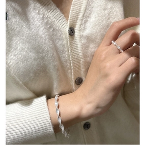 Detailed close-up of S925 sterling silver wave ring and bracelet with spiral twisted texture