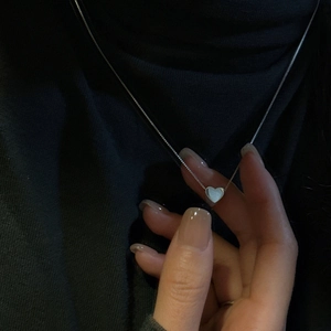 Collier minimaliste avec pendentif cœur en argent S925 sur pull à col roulé noir