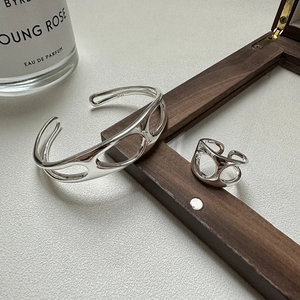 Modern S925 sterling silver hollow jewelry set featuring a wide bangle and a minimalist ring