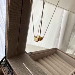 Collier avec pendentif cœur doré pour femme présenté sur un miroir de boîte à bijoux