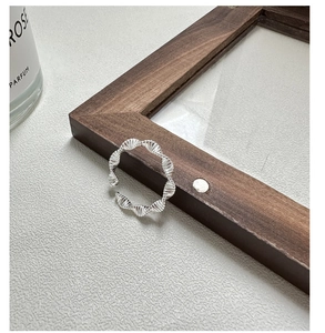 Detailed view of S925 sterling silver ring with elegant wave twist texture and open band