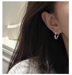 Nahaufnahme der S925 Sterling Silber Creolen mit Plissee-Textur am Ohr eines weiblichen Models