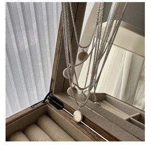 Macro shot of S925 silver multi-layer necklace with shimmering baroque pearl pendants