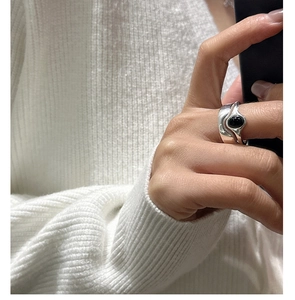 Macro view of vintage silver ring with wavy texture and oval black onyx gemstone