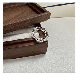 Macro shot of S925 sterling silver pig nose anchor chain ring on a wooden jewelry box