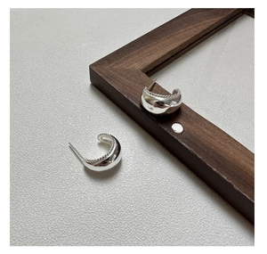 Detailed view of S925 silver C-shape earrings with mirror finish and beaded texture