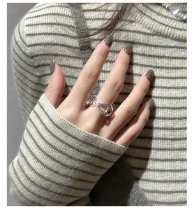 Detail of S925 sterling silver pig nose ring with irregular knot design on model's hand