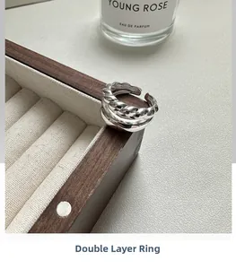 Detail view of S925 sterling silver double-layered ring with twist texture on wood stand