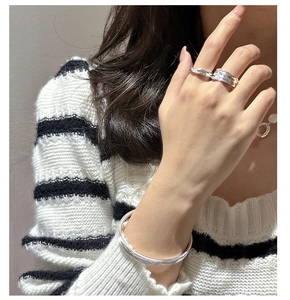 Detail view of irregular textured 925 sterling silver ring and sleek minimalist bracelet
