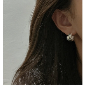 Detail of S925 sterling silver curved earring with beaded edges on model's ear