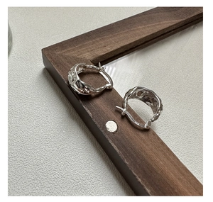 Dettaglio degli orecchini a U in argento sterling S925 con texture martellata e marchio