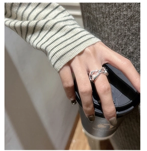 Detail of S925 sterling silver pig nose ring worn by model holding a coffee cup