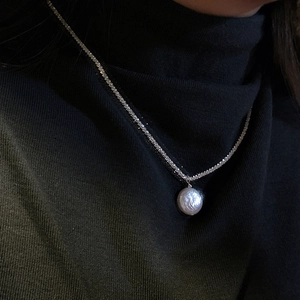 Elegant S925 sterling silver necklace featuring a shimmering chain and a baroque pearl pendant