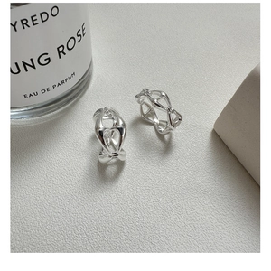 Macro shot of silver geometric hollow hoop earrings with a minimalist modern design