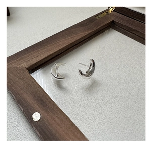 Vue macro de boucles d'oreilles minimalistes en argent S925 en forme de lune avec fini poli