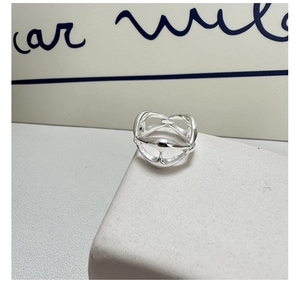Detail shot of a minimalist S925 silver hollow link ring on a white display stand