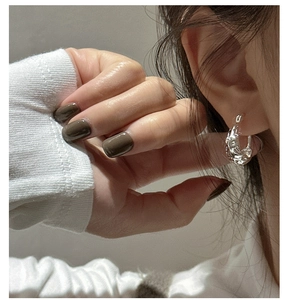 Dettaglio di modella che indossa orecchini a cerchio a U in argento S925 effetto liquido