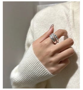 Close-up of S925 sterling silver croissant ring and twisted band stacked on hand