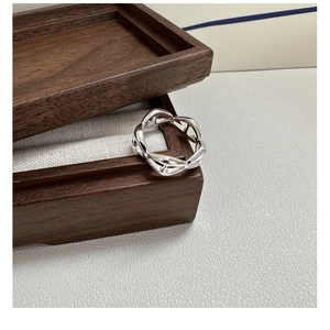 Macro shot of silver-toned S925 sterling silver chain link ring on a wooden jewelry box
