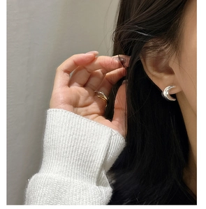 Détail des boucles d'oreilles lune en argent S925 et bagues superposées bicolores