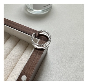Detailed view of S925 sterling silver double-layer twisted ring on wooden box