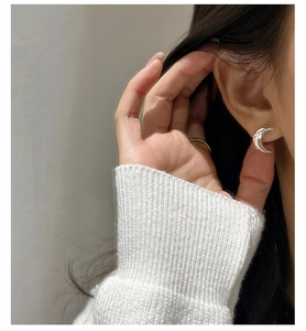 Gros plan de boucles d'oreilles demi-lune en argent 925 portées par un mannequin