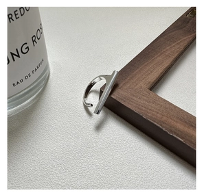 Macro shot of minimalist S925 sterling silver bar ring on elegant wooden display