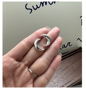 Gros plan de boucles d'oreilles croissants de lune en argent S925 poli sur la main