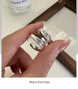 Detailed close-up of S925 sterling silver earrings with irregular pleated texture design