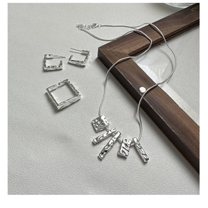 Makro-Detail von silbernem Schmuckset mit Hammerschlag-Textur auf S925er Sterlingsilber-Stücken