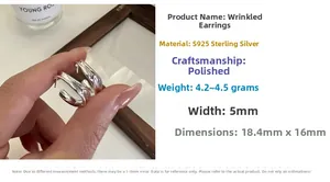 Macro detail of S925 sterling silver pleated C-shape earrings with polished finish