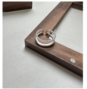 Close-up of double-layered S925 silver ring featuring twisted rope and smooth band textures