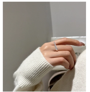 Macro detail of a minimalist S925 sterling silver bar ring on a finger for daily wear