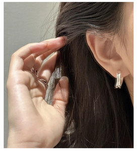 Macro shot of liquid metal style S925 silver irregular lava stream curve earrings