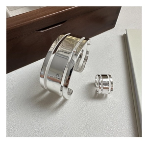 Detail view of wide-faced triple-layer hollow silver bracelet and matching ring set