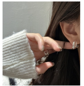 Close-up of S925 sterling silver hammered earrings and chain ring on elegant model