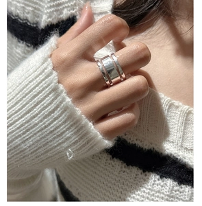 Detail of a minimalist S925 sterling silver triple-layer wide ring worn on finger