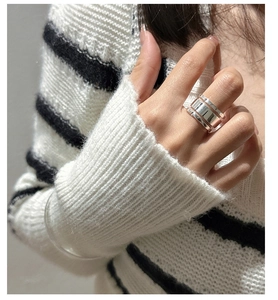 Detail of S925 sterling silver three-layer wide ring worn on hand with knitwear