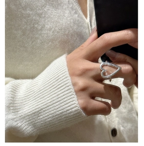 Close-up of a large hollow heart-shaped S925 sterling silver ring on a model finger