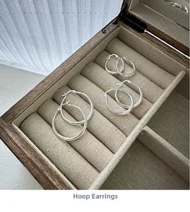 Detailed view of three pairs of silver hoop earrings in small, medium, and large sizes