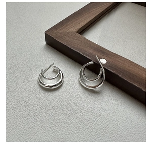 Detail of S925 sterling silver double-layer curved earrings with hammered texture