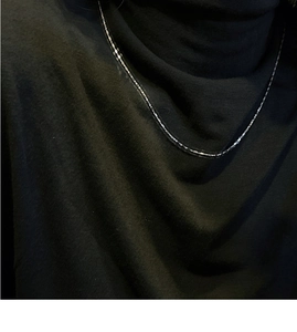 Macro detail of fine S925 sterling silver square link chain necklace on model