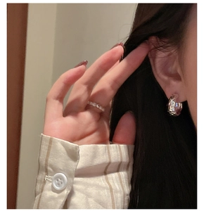 Gros plan de boucles d'oreilles en argent S925 avec texture martelée sur un mannequin